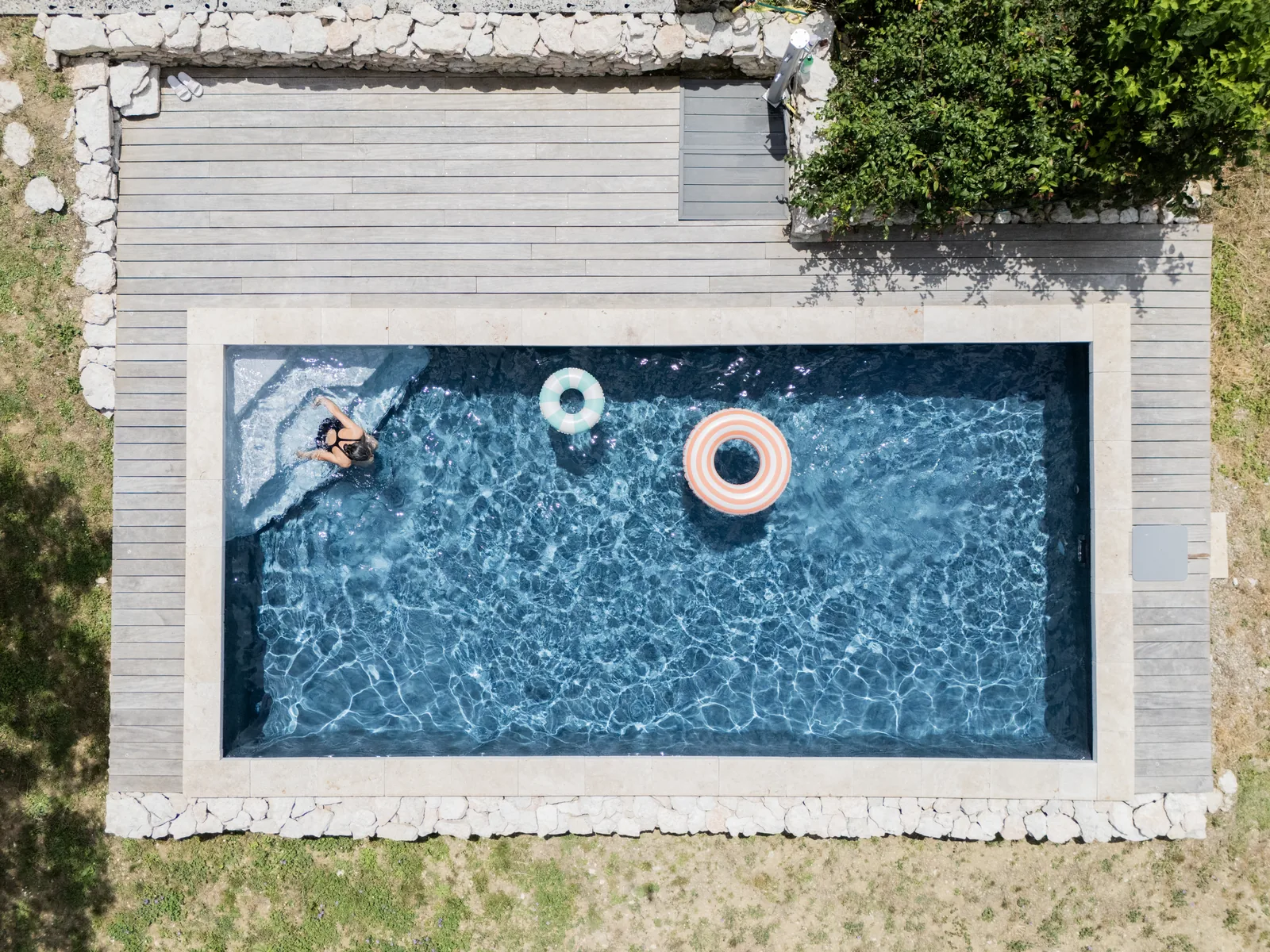 Rechteckiger Design Pool mit Holzterrasse aus der Vogelperspektive